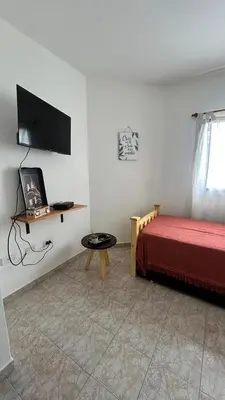 a bedroom with a bed and a table and a tv at 760 B Apartamentos in Alta Gracia