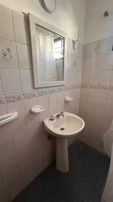 a white bathroom with a sink and a mirror at 760 B Apartamentos in Alta Gracia