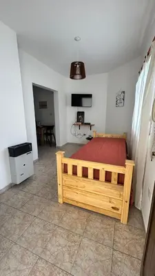 a bedroom with a wooden bed with a red blanket at 760 B Apartamentos in Alta Gracia