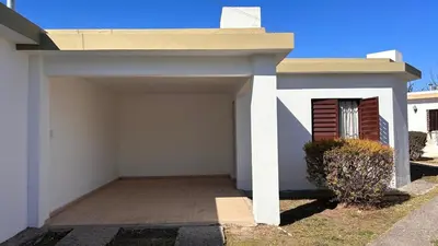 a garage in front of a white house at 760 B Apartamentos in Alta Gracia