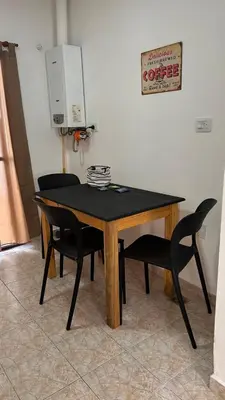 a table with two chairs and a coffee sign on the wall at 760 B Apartamentos in Alta Gracia