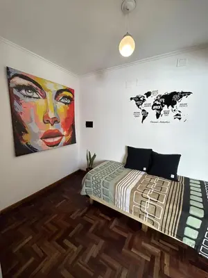 a bedroom with a bed and a painting on the wall at Departamento Nueva Cordoba in Cordoba