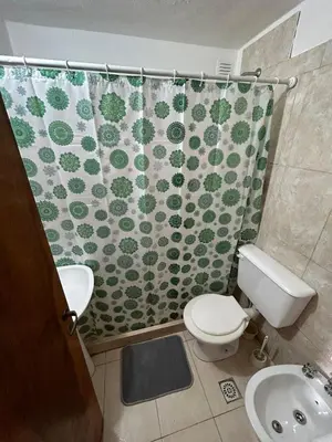 a bathroom with a shower curtain with a toilet and a sink at Departamento Nueva Cordoba in Cordoba