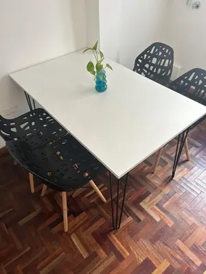 a white table with chairs and a vase with a plant at Departamento Nueva Cordoba in Cordoba