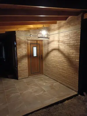 a brick wall with a wooden door and a light at Siu Kiu - Casa de Montaña in El Parador
