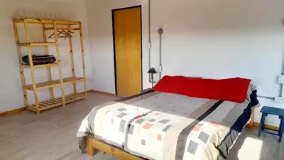 a bedroom with a bed with a red pillow at Siu Kiu - Casa de Montaña in El Parador