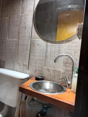 a bathroom with a sink and a toilet and a mirror at Siu Kiu - Casa de Montaña in El Parador