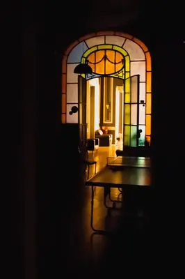 a room with a table and a stained glass window at Hostel Alvear in Cordoba