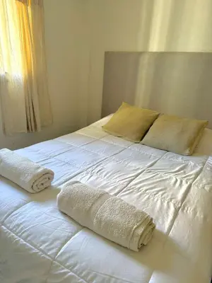 a white bed with two towels on top of it at Tránsito in Cordoba