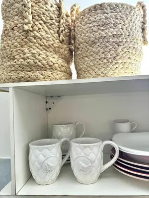 two cups and plates on a shelf with baskets at Tránsito in Cordoba