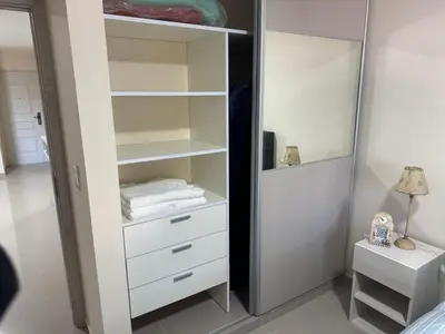 a closet with white drawers and a mirror at Cálido departamento en la mejor zona de Alta Córdoba in Cordoba