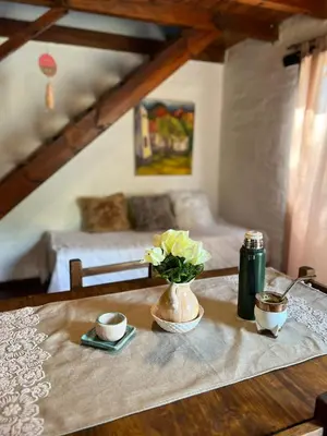 a table with a vase of flowers on top of it at Cabañas La Felicidad in Merlo