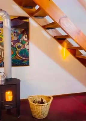 a room with a woodburning stove and a basket at Cabañas La Felicidad in Merlo