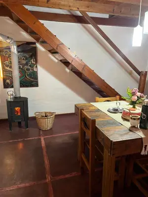 a room with a table and a wood stove at Cabañas La Felicidad in Merlo