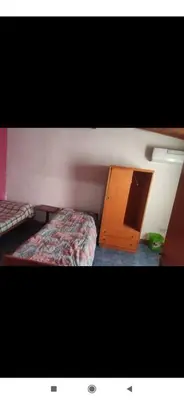 a bedroom with a bed and a wooden cabinet at Depto mina clavero Córdoba zona residencial in Mina Clavero