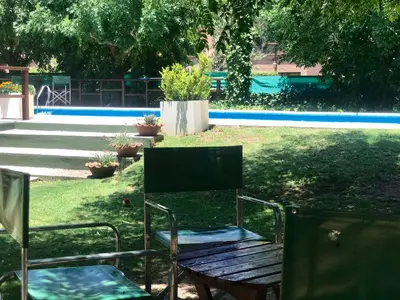 a park with a bench and a table and chairs at Hotel Complejo Najul Suites-Solo Adultos in Mina Clavero