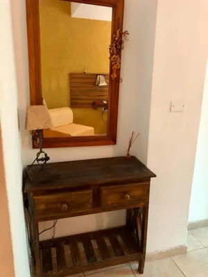 a wooden dresser with a mirror on a wall at Hotel Complejo Najul Suites-Solo Adultos in Mina Clavero