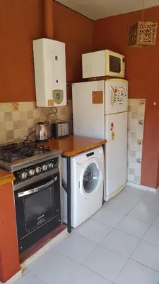 a kitchen with a stove and a refrigerator and a washing machine at Achaval-Torre in Cordoba