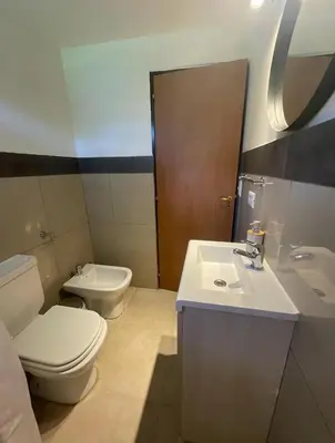 a bathroom with a white toilet and a sink at Casa Reartes in Los Reartes