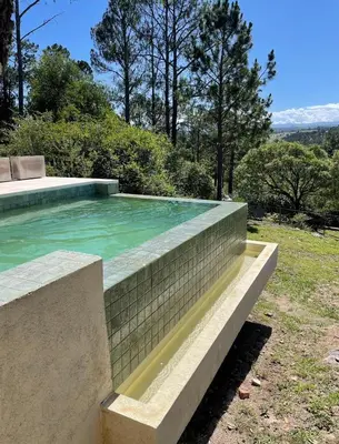 a swimming pool with a brick retaining wall at Casa Reartes in Los Reartes