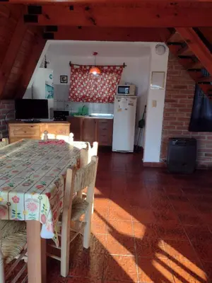 a kitchen with a table and a kitchen with a refrigerator at Alpinas San Lorenzo in Merlo