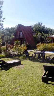 a picnic table and benches in front of a house at Alpinas San Lorenzo in Merlo