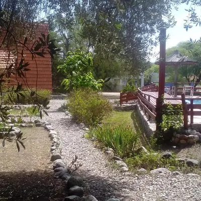 a garden with a stone path and a fence at Alpinas San Lorenzo in Merlo