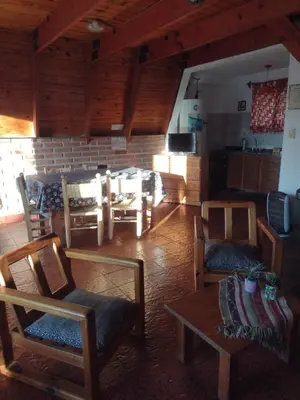 a living room with wooden chairs and a table at Alpinas San Lorenzo in Merlo
