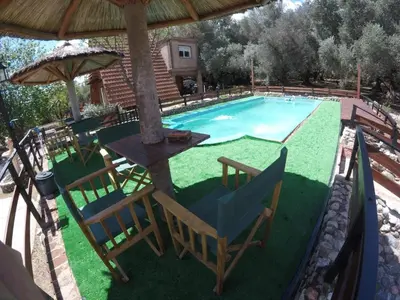 a pool with chairs and a table and an umbrella at Alpinas San Lorenzo in Merlo
