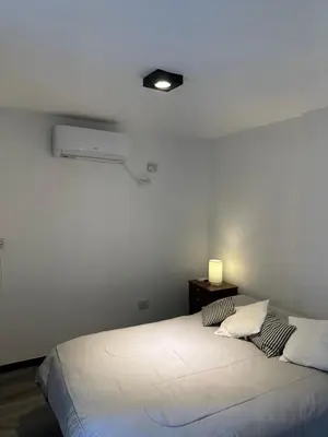 a bed in a room with a white wall at Magnolia in Cordoba