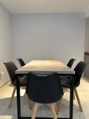 a wooden table with black chairs around it at Magnolia in Cordoba