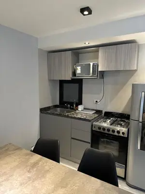 a kitchen with a table and a stove and a microwave at Magnolia in Cordoba