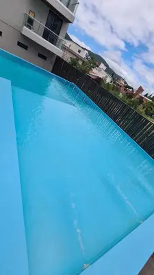 a pool of blue water in front of a building at Sundara Tan perfecto que no vas a querer irte in Villa Carlos Paz