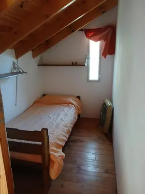 a small bedroom with a bed and a window at Cabañas El Duende in Quines