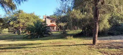 a house in the middle of a field with trees at Cabañas El Duende in Quines