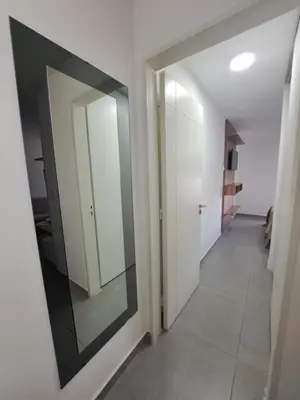 a hallway with white walls and a large mirror at Departamento -Roma- Barrio General Paz - A una cuadra de 24 de septiembre y enfrente del Polideportivo By Apartcba in Cordoba