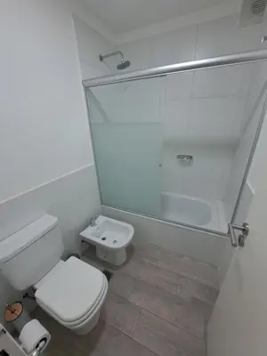 a white bathroom with a toilet and a shower at Departamento -Roma- Barrio General Paz - A una cuadra de 24 de septiembre y enfrente del Polideportivo By Apartcba in Cordoba