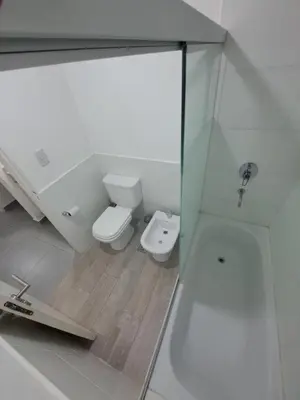 a white bathroom with a toilet and a shower at Departamento -Roma- Barrio General Paz - A una cuadra de 24 de septiembre y enfrente del Polideportivo By Apartcba in Cordoba