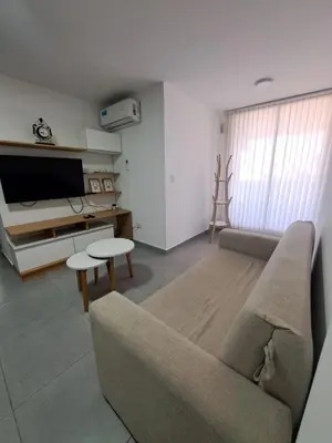a living room with a couch and a tv at Departamento -Roma- Barrio General Paz - A una cuadra de 24 de septiembre y enfrente del Polideportivo By Apartcba in Cordoba