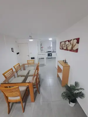 a dining room with a table and chairs and a kitchen at Departamento -Roma- Barrio General Paz - A una cuadra de 24 de septiembre y enfrente del Polideportivo By Apartcba in Cordoba