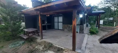 a blue building with a bench in front of it at Cabañas La Arbolada in El Durazno