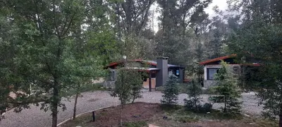 a small house in the middle of a forest at Cabañas La Arbolada in El Durazno