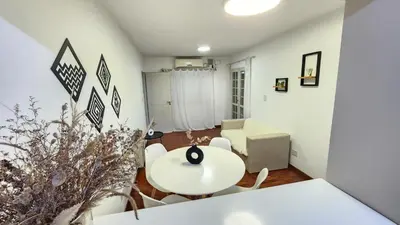 a living room with a white table and chairs at Departamento PB, patio y asador privados - NUEVO SERVICIO Estacionamiento 24hs INCLUIDO, no camioneta- Cerca de hotel Quinto Centenario, Nuevocentro shopping, Hospital Clinicas y Club Universitario Córdoba Sede central in Cordoba