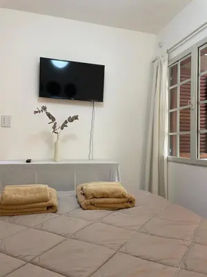 a bedroom with a bed with two towels on it at Departamento PB, patio y asador privados - NUEVO SERVICIO Estacionamiento 24hs INCLUIDO, no camioneta- Cerca de hotel Quinto Centenario, Nuevocentro shopping, Hospital Clinicas y Club Universitario Córdoba Sede central in Cordoba