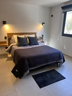 a bedroom with a large bed with a blue blanket at JC Apart in Cordoba