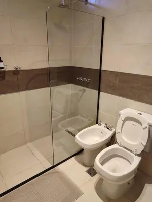 a bathroom with a toilet and a glass shower at JC Apart in Cordoba