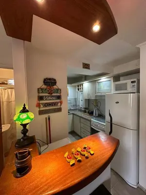 a kitchen with a table and a white refrigerator at Departamento Nueva Córdoba 7 A INVERHOME INMOBILIARIA in Cordoba