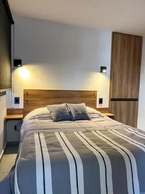 a bedroom with a large bed with a striped blanket at JC Apart 3 in Cordoba