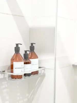 two bottles of soap on a shelf in a bathroom at JC Apart 3 in Cordoba