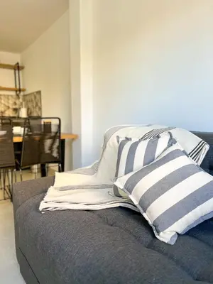 a bed with striped pillows on it in a room at JC Apart 3 in Cordoba